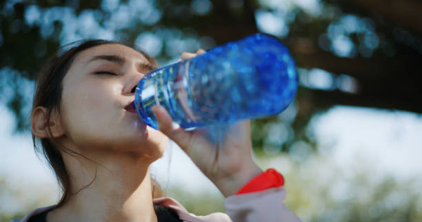 istock Runner young woman taking a break from working out to drink water 1999290343