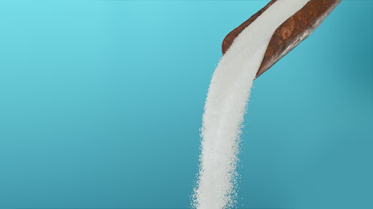 Super slow motion white ground sugar falling from a rusty scoop