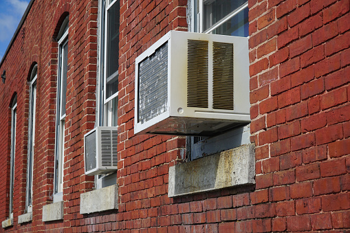 old air conditioner installed on old brick wall building