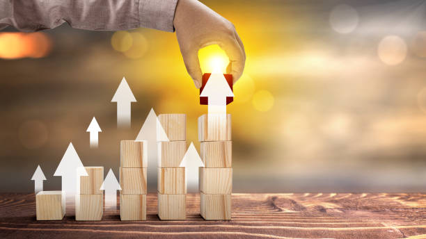 istock Business hand put stair stack of a wooden cube with increased graph arrow 1999407701