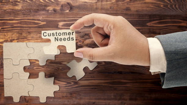 istock Business hand holding pieces of a jigsaw puzzle with customer needs text 1999410905