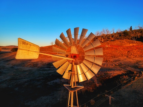 A windmill catching the afternoon light in the snowy mountains.