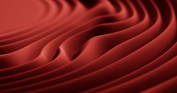 A close-up perspective capturing the intricate patterns and textures produced by waves on red matte plastic.