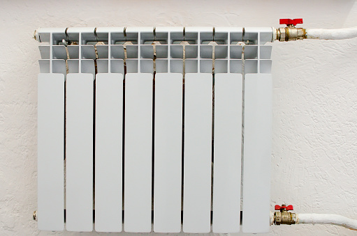 A white heating radiator hangs on the wall.