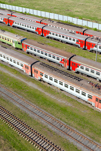 Flight over passenger trains at the railway station on a summer day.