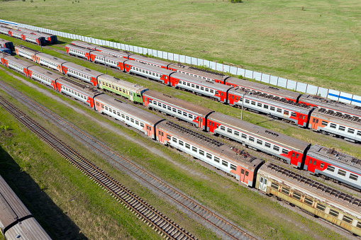 Flight over passenger trains at the railway station on a summer day.