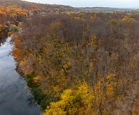 Aerial autumn river landscape and cloudy sky. Wild colorful autumnal riverside nature in Ukraine
