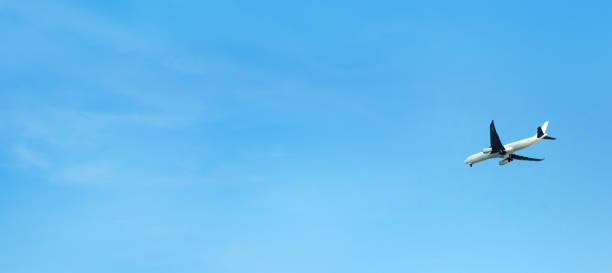 istock Flying commercial passenger airplane over blue sunny sky 1999604160