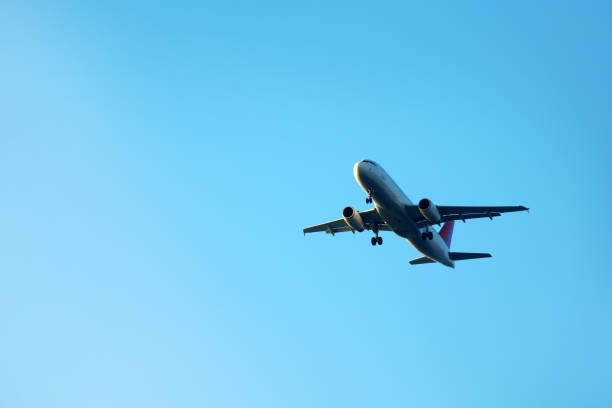 istock Flying commercial passenger airplane over blue sunny sky 1999604173