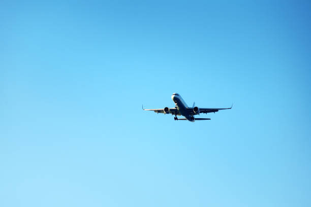 istock Flying commercial passenger airplane over blue sunny sky 1999606232