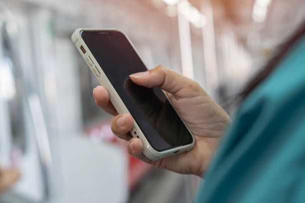 istock Cropped view of woman using her cell phone on subway platform, message sms e-mail. 1999640343