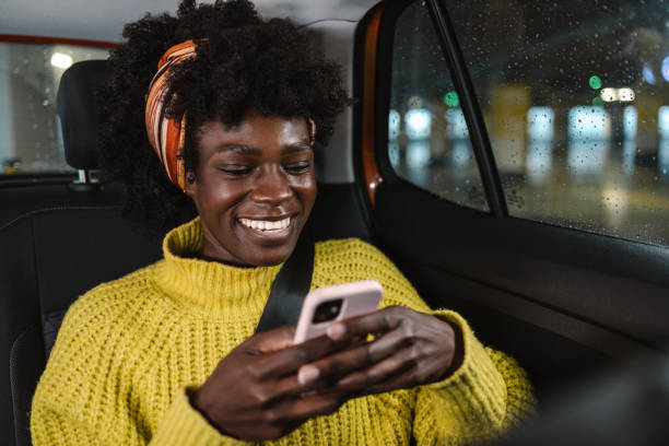 istock Young woman using smart phone in a cab 1999669335