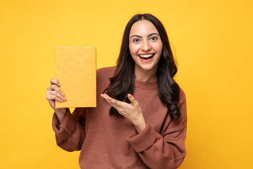 Portrait of female college student on yellow background