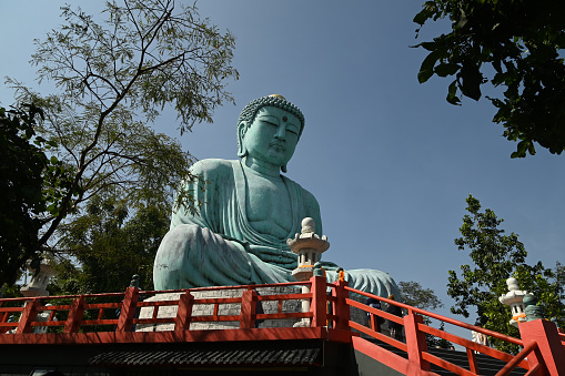 Outdoor great Buddha Daibutsu or Amitabhe Buddha at Wat Pra That Doi Pra Chan. It is a green rust Buddha statue made from a mixture of copper that was used to create it.