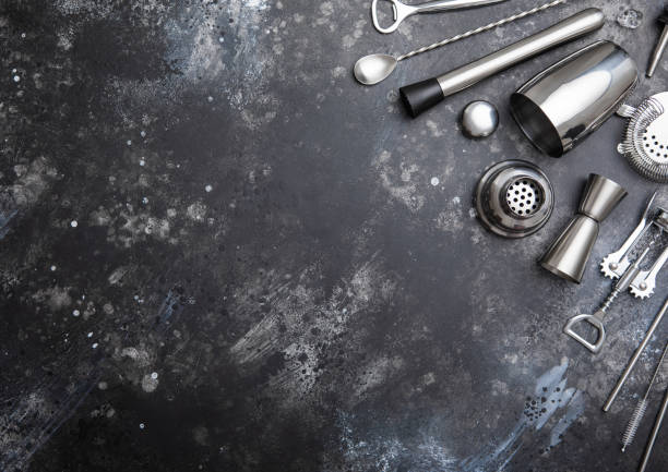 istock Bar cocktail stainless steel utensils set on black stone background. Shaker,muddler,strainer,straw,jigger and wine opener. 1999701475