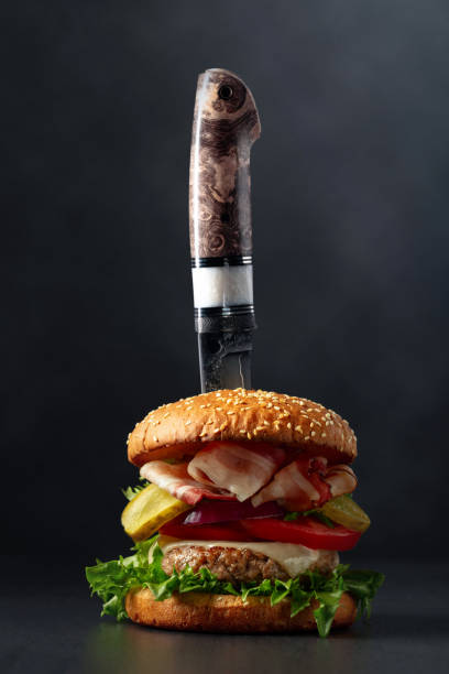 istock Fresh tasty burger with knife on a black background. 1999737336