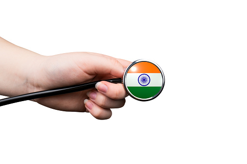 The head of a medical stethoscope in the form of an Indian flag in a hand (close-up) isolated on a white background. Indian healthcare system concept