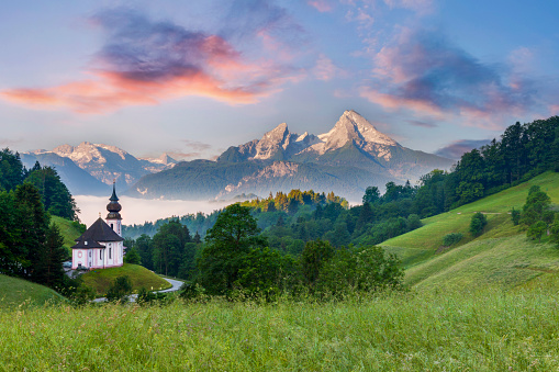 eautiful mountain landscape in the Bavarian Alps with famous pilgrimage church of Maria Gern and Watzmann massif in golden morning light, Nationalpark Berchtesgadener Land, Bavaria, Germany
