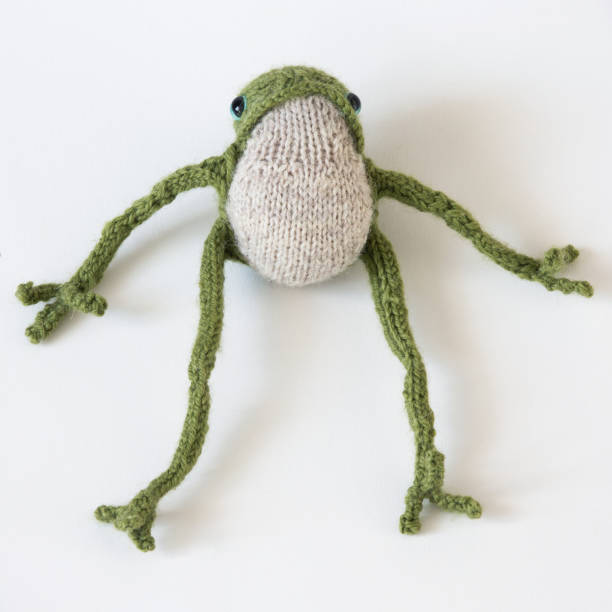 istock Knitted green frog with long legs 1999765621