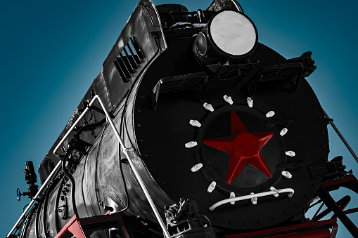 Black cabin of old soviet steam locomotive with red star, close up, dramatic and contrast