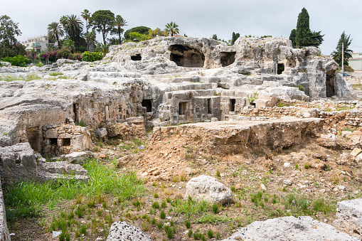 Syracuse, Italy-May 9, 2022:View of the famous and vast natural park in Syracuse with an ancient Greek theatre, a church, caves and other remains from the Roman era.