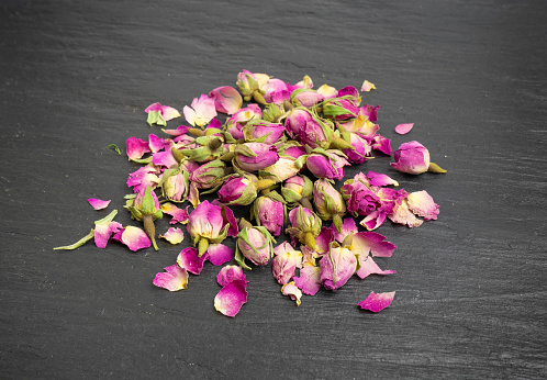 Dry Rose Buds, Roses Petals for Pink Flower Tea, Dried Persian Rosebuds, Rose Buds Textured Flowers on Black Stone Plate Background
