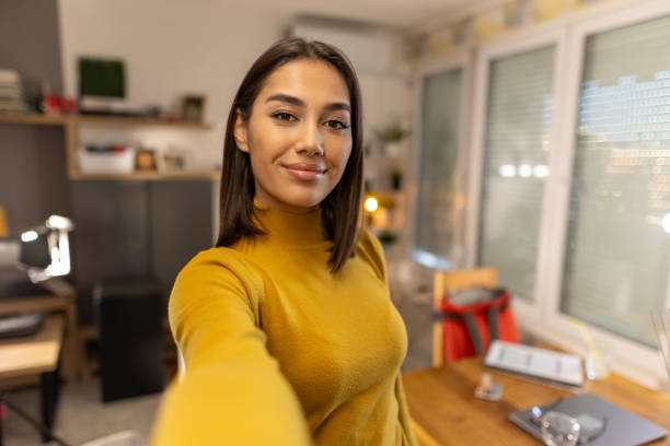 istock Beautiful young woman taking selfie at home 1999834052