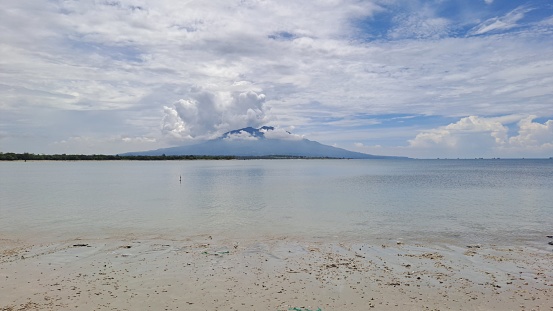 Background A view of a cloud-covered mountain in the middle of the ocean at M Beach Lampung Indonesia