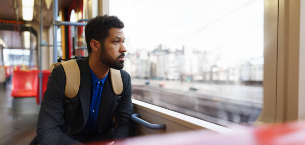 istock Handsome man traveling by city train, scrolling on a smartphone. Single man using dating app. 1999845402
