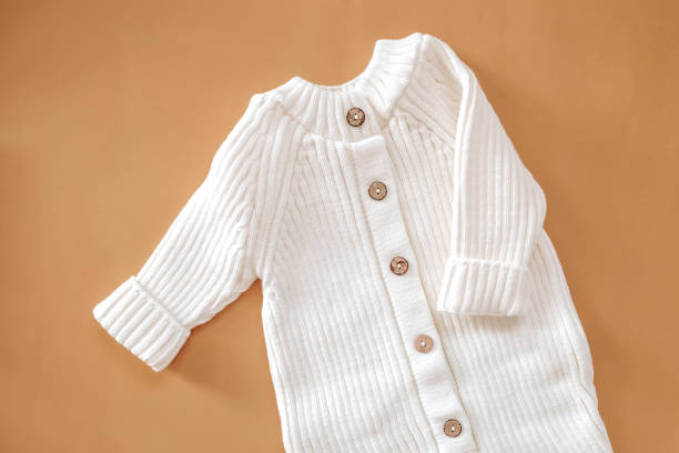 istock Jumpsuits for newborns on a beige background. Spring clothes for children 1999852143