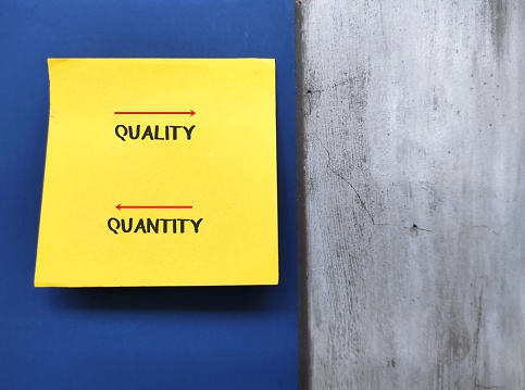 Yellow on copy space blue background with text Quality and Quantity,comparative measurement between how good something is versus how much, to identify what production work best