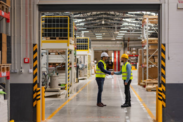 istock Engineer shaking hands with project manager in modern industrial factory, talking about new production project. Team management in manufacturing facility. 1999874355
