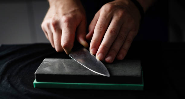 Male Hands Sharpening Kitchen Knife With Whetstone