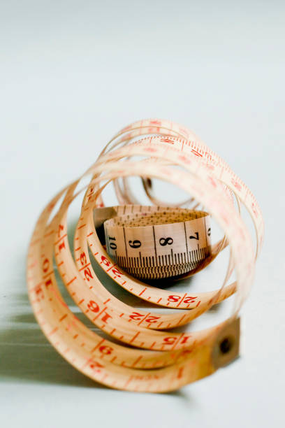 istock Close up tailor measuring tape isolated on blue background 1999928459