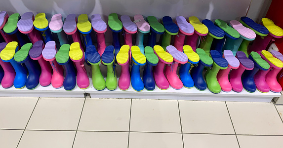 Colorful rubber rain boots for kids in a store.