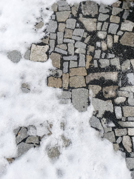 Cobblestone partially covered with snow.