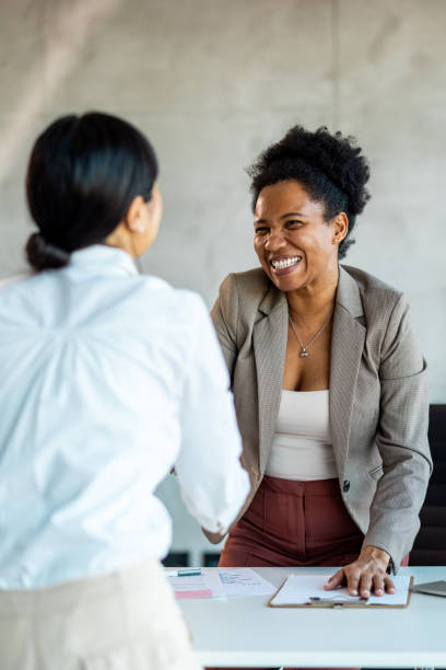 istock A young woman smiling and shaking hands with a client, after concluding a contract 1999929066