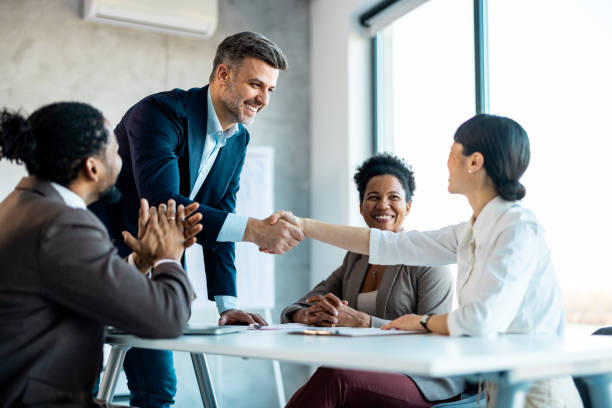 istock Middle aged man executive manager company representative welcoming business partner while standing in modern office boardroom 1999929133