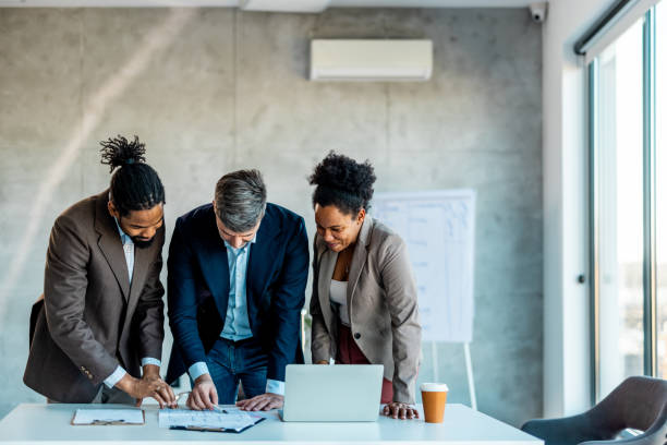 istock Friendly businessman explaining business plan at meeting, working with documents 1999929245