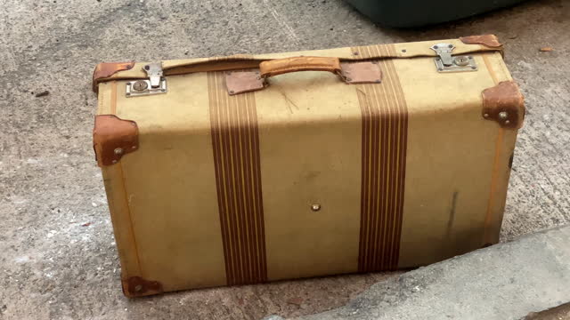 Old-fashioned suitcase left in the street