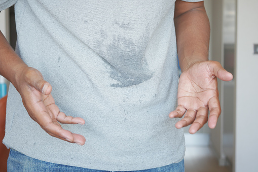 men hands with spilled water over his shirt.