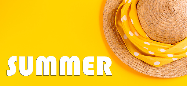 The word summer written in letters on a yellow background with a straw hat. The concept of rest, vacation. Banner.