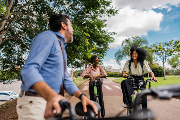 istock Coworkers talking and riding a bicycle at the public park 1999951673