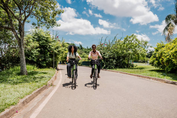 istock Coworkers riding a bicycle at public park 1999952711