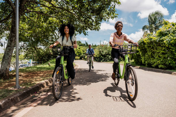 istock Coworkers riding a bicycle at public park 1999952717