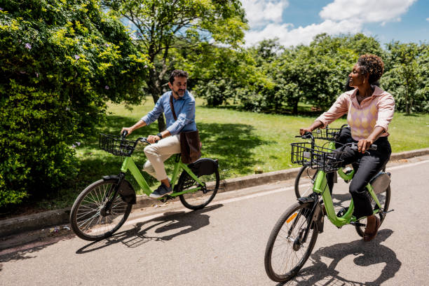 istock Coworkers riding a bicycle at public park 1999952722