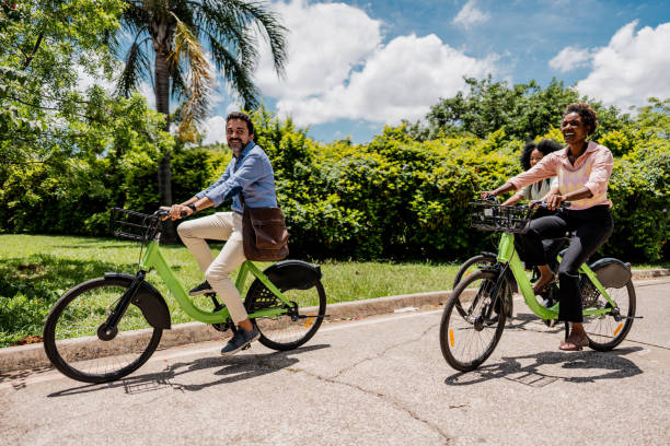 istock Coworkers riding a bicycle at public park 1999953235