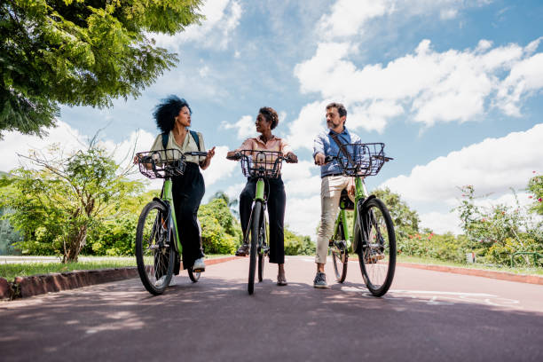 istock Coworkers riding a bicycle at public park 1999953236