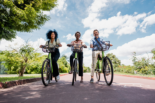 Portrait of coworkers riding a bicycle at public park