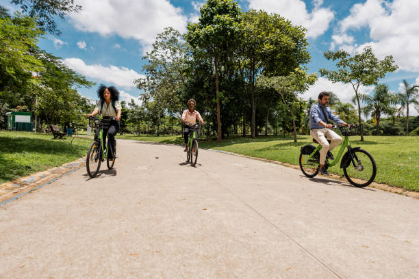 istock Coworkers riding a bicycle at public park 1999953745